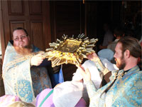 Богомольцы проходят под святой иконой