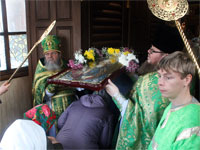 Верующие проходят под иконой праздника